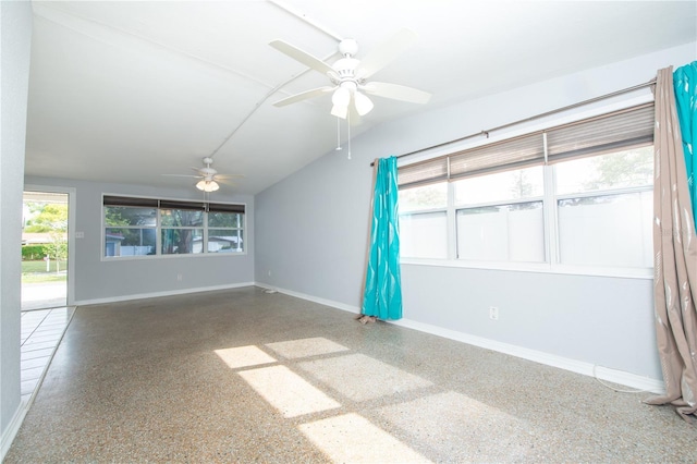 empty room featuring baseboards, speckled floor, and a ceiling fan