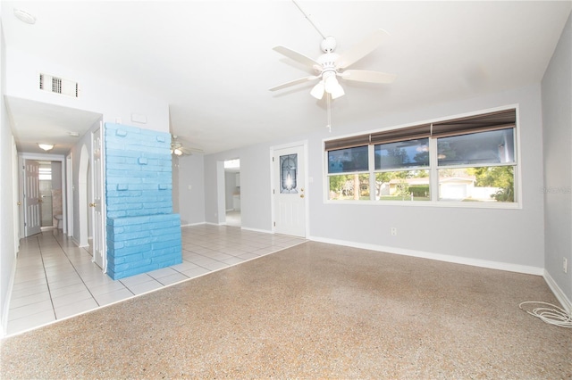 unfurnished living room with plenty of natural light, baseboards, ceiling fan, and visible vents