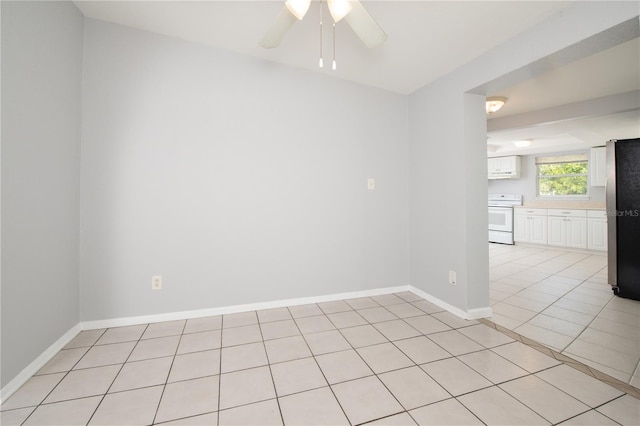 spare room featuring baseboards, ceiling fan, and light tile patterned floors