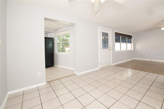 unfurnished room with a ceiling fan, light tile patterned floors, and baseboards