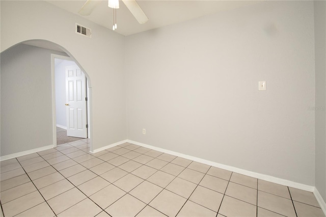 empty room featuring baseboards, visible vents, arched walkways, and ceiling fan