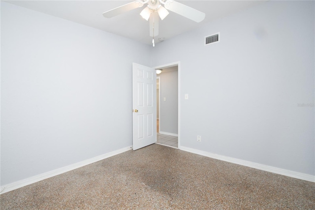 empty room with speckled floor, baseboards, ceiling fan, and visible vents