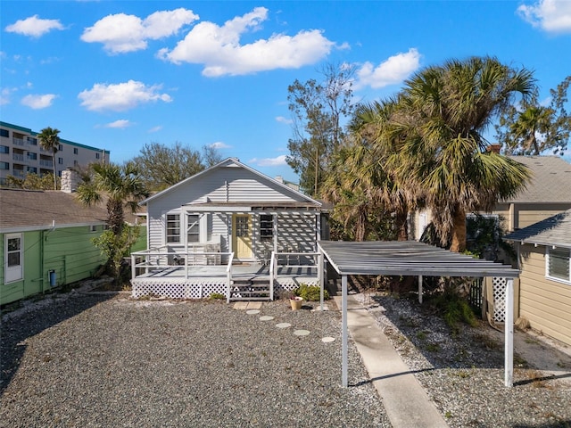 back of property featuring a detached carport and a wooden deck