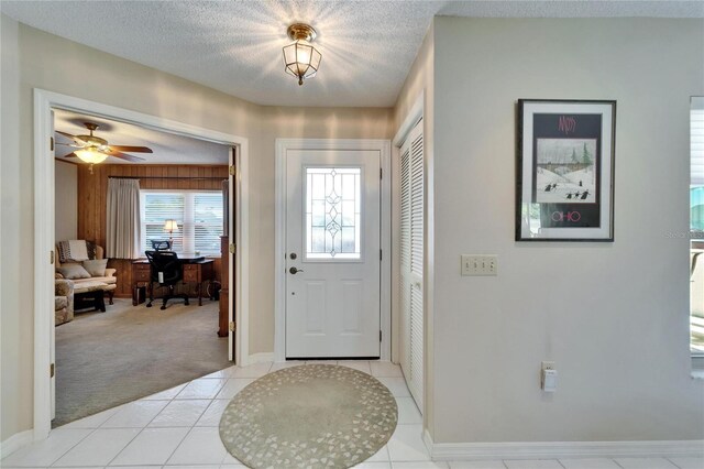 2007 E View Dr, Sun City Center, FL 33573 - entryway with light tile patterned floors, light colored carpet, a ceiling fan, and a textured ceiling