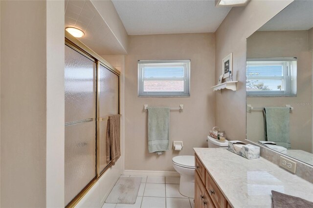 2007 E View Dr, Sun City Center, FL 33573 - full bathroom featuring vanity, baseboards, enclosed tub / shower combo, tile patterned flooring, and toilet