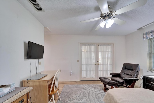 2007 E View Dr, Sun City Center, FL 33573 - bedroom featuring visible vents, french doors, wood finished floors, a textured ceiling, and a ceiling fan