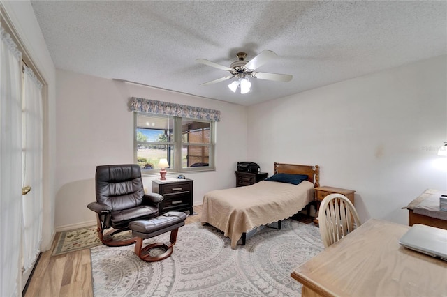 2007 E View Dr, Sun City Center, FL 33573 - bedroom featuring a ceiling fan, wood finished floors, baseboards, and a textured ceiling