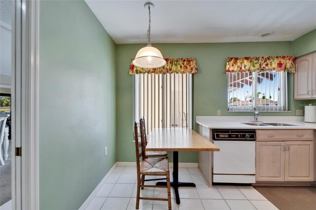 2007 E View Dr, Sun City Center, FL 33573 - kitchen with baseboards, light countertops, light tile patterned floors, white dishwasher, and a sink