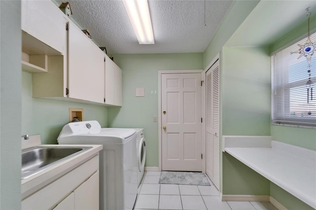2007 E View Dr, Sun City Center, FL 33573 - laundry area with washer and clothes dryer, a sink, a textured ceiling, cabinet space, and light tile patterned floors