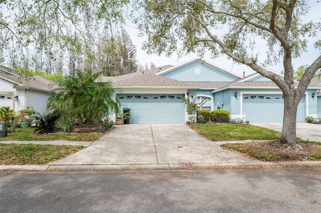 single story home with driveway, a garage, and stucco siding
