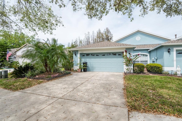 ranch-style home featuring a front yard, driveway, stucco siding, and an attached garage