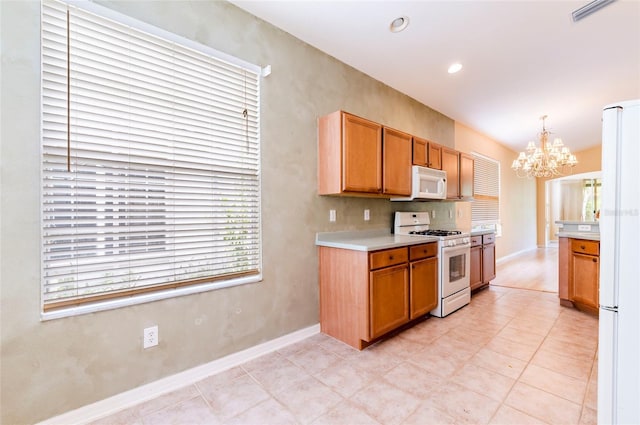 kitchen featuring light countertops, white appliances, an inviting chandelier, pendant lighting, and visible vents