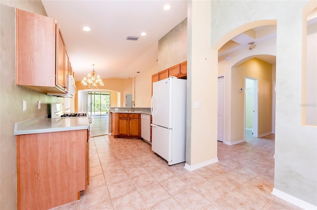 kitchen featuring light countertops, white appliances, baseboards, a sink, and a notable chandelier
