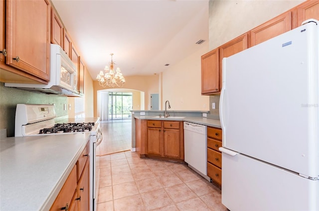kitchen with light countertops, a sink, a chandelier, a peninsula, and white appliances
