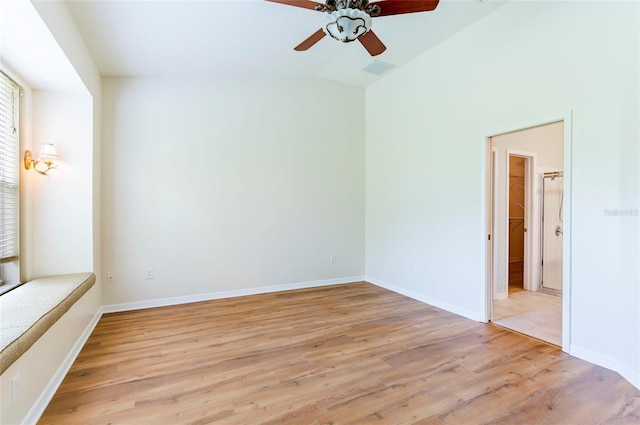unfurnished room featuring lofted ceiling, light wood-type flooring, baseboards, visible vents, and ceiling fan
