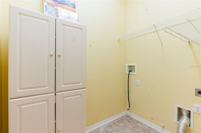laundry room featuring hookup for an electric dryer, light tile patterned floors, baseboards, cabinet space, and hookup for a gas dryer