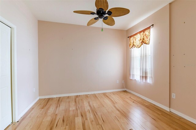 spare room featuring baseboards, a ceiling fan, and light wood finished floors