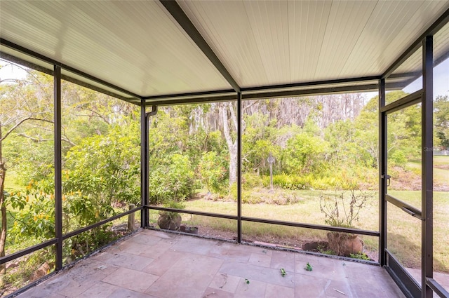 unfurnished sunroom featuring a view of trees