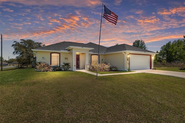 view of front of house with stucco siding, a lawn, roof with shingles, concrete driveway, and a garage