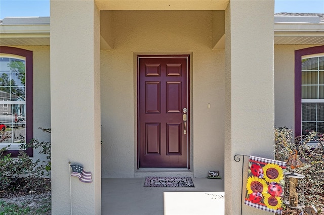view of exterior entry featuring stucco siding