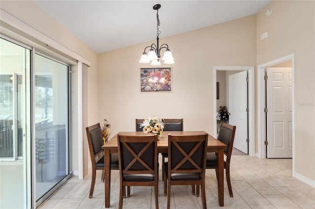 dining space featuring baseboards, lofted ceiling, an inviting chandelier, and light tile patterned flooring