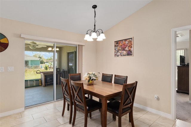 dining area with light carpet, a notable chandelier, lofted ceiling, light tile patterned floors, and baseboards