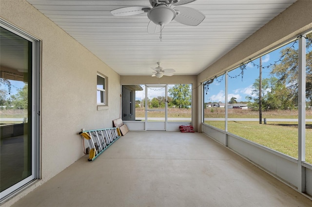 unfurnished sunroom featuring ceiling fan