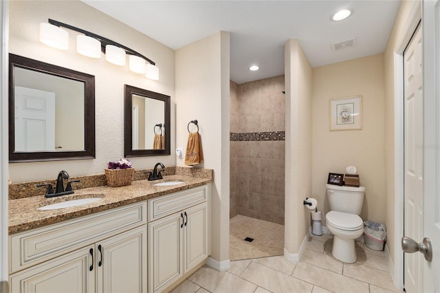 bathroom with a sink, visible vents, a walk in shower, and tile patterned flooring