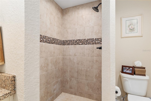 full bathroom with a textured wall, toilet, and a tile shower