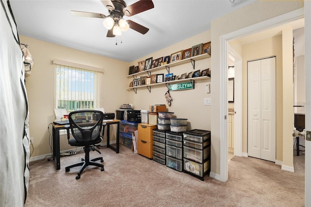 carpeted office with a ceiling fan and baseboards