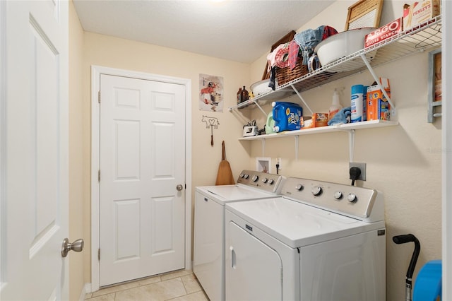 washroom with light tile patterned flooring, laundry area, and washer and clothes dryer