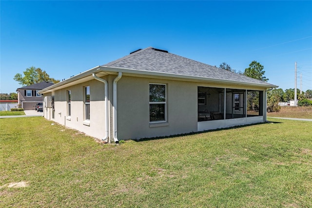 back of house featuring stucco siding, a yard, and roof with shingles
