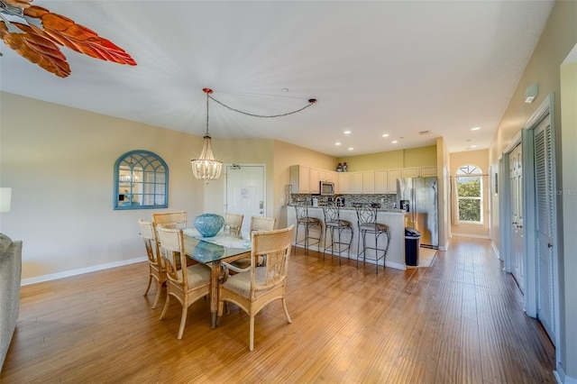 19829 Gulf Blvd Unit 601, Indian Shores, FL 33785 - dining room featuring an inviting chandelier, light wood-type flooring, and baseboards