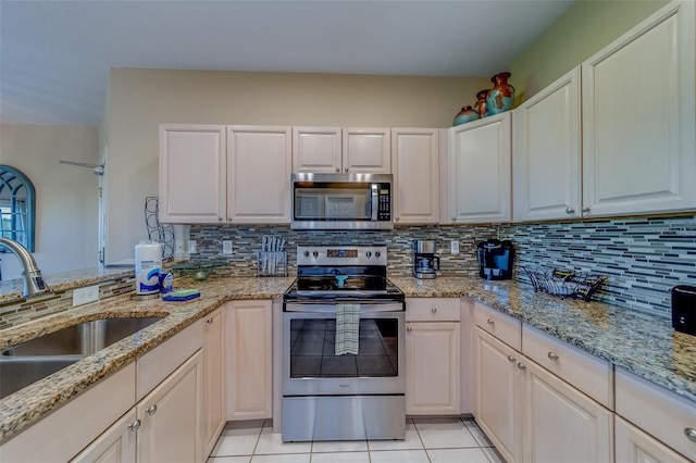19829 Gulf Blvd Unit 601, Indian Shores, FL 33785 - kitchen with light tile patterned flooring, backsplash, stainless steel appliances, and a sink