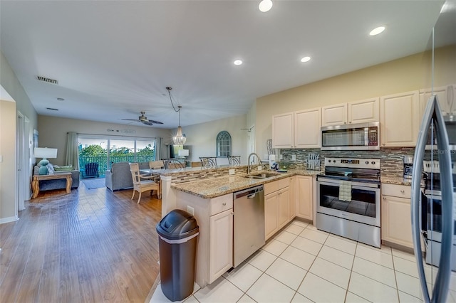 19829 Gulf Blvd Unit 601, Indian Shores, FL 33785 - kitchen featuring a ceiling fan, a peninsula, a sink, stainless steel appliances, and open floor plan