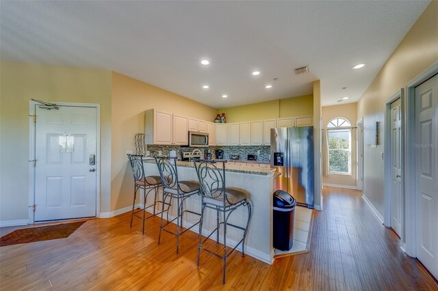 19829 Gulf Blvd Unit 601, Indian Shores, FL 33785 - kitchen featuring a peninsula, light wood-style floors, visible vents, and appliances with stainless steel finishes