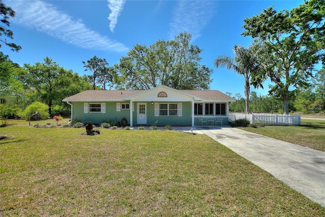 single story home with concrete driveway, a front lawn, and fence