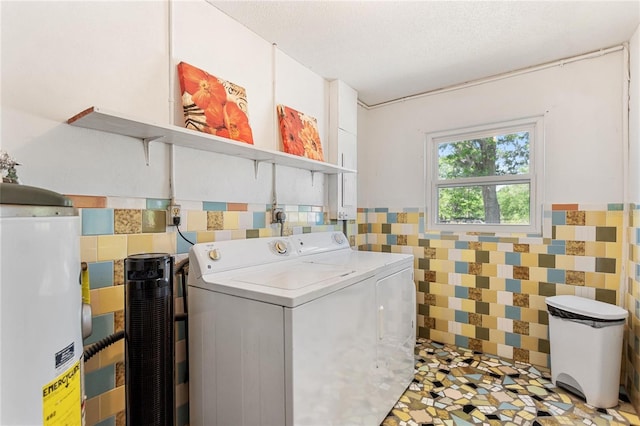 laundry room featuring tile walls, a wainscoted wall, laundry area, independent washer and dryer, and a textured ceiling
