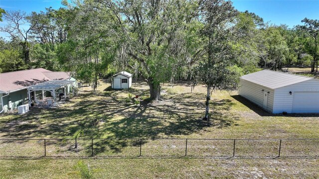 view of yard featuring an outdoor structure, fence, and a pergola