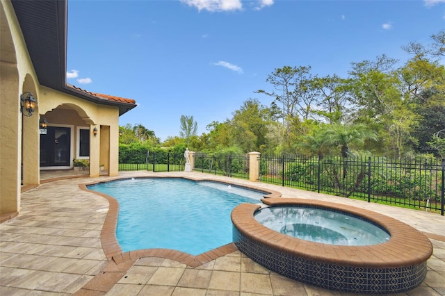 view of swimming pool featuring a pool with connected hot tub, a fenced backyard, and a patio area