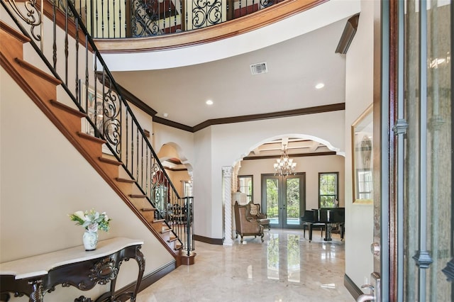 entryway with stairway, visible vents, baseboards, arched walkways, and french doors