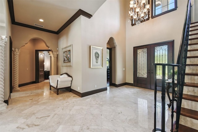 foyer featuring visible vents, marble finish floor, arched walkways, baseboards, and stairs