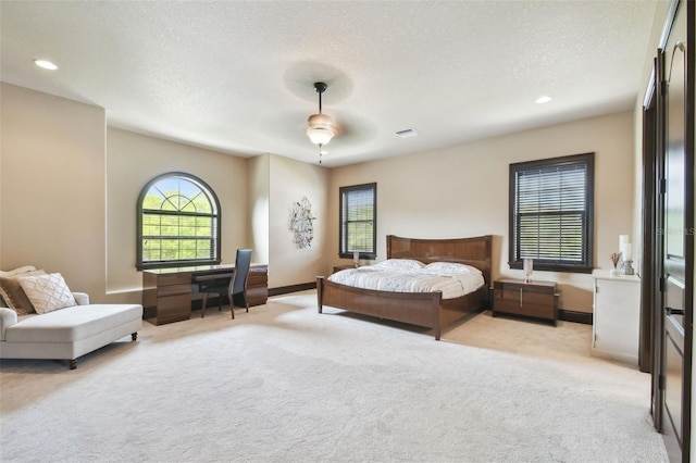 bedroom with visible vents, a textured ceiling, recessed lighting, baseboards, and light colored carpet