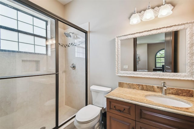 bathroom with vanity, a shower stall, and toilet