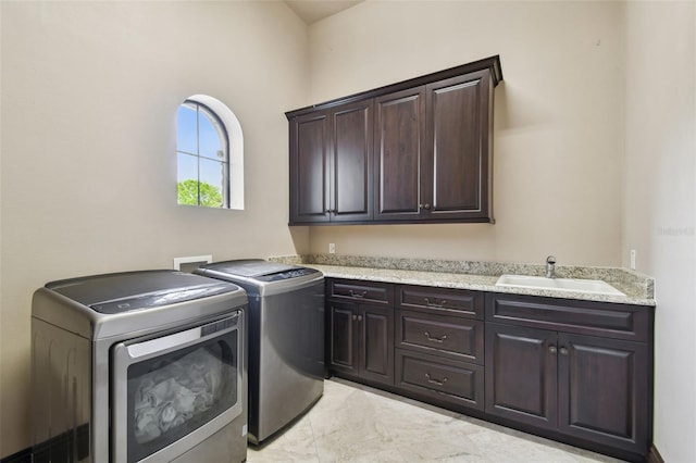 washroom featuring washer and clothes dryer, cabinet space, and a sink