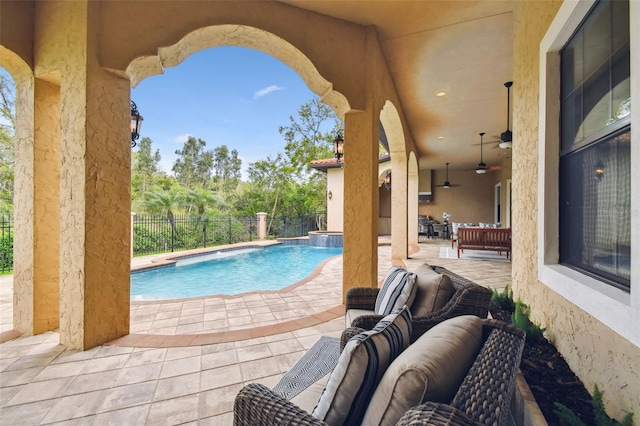 view of swimming pool featuring a ceiling fan, fence, a pool with connected hot tub, a patio area, and an outdoor hangout area