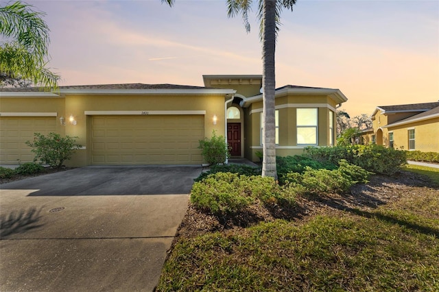 view of front of house featuring concrete driveway, an attached garage, and stucco siding