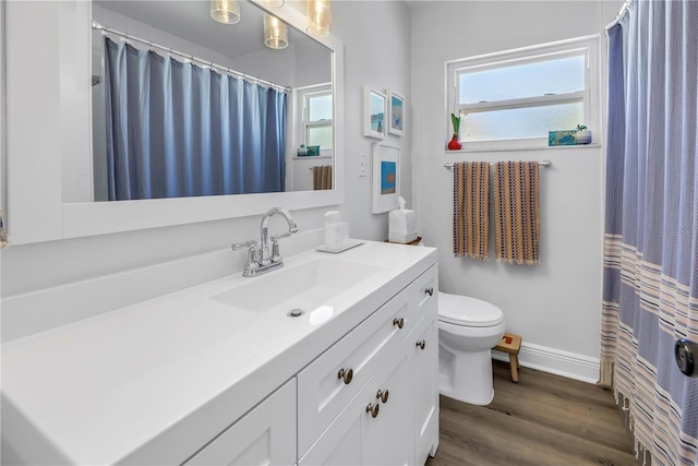 full bathroom with baseboards, wood finished floors, toilet, and vanity