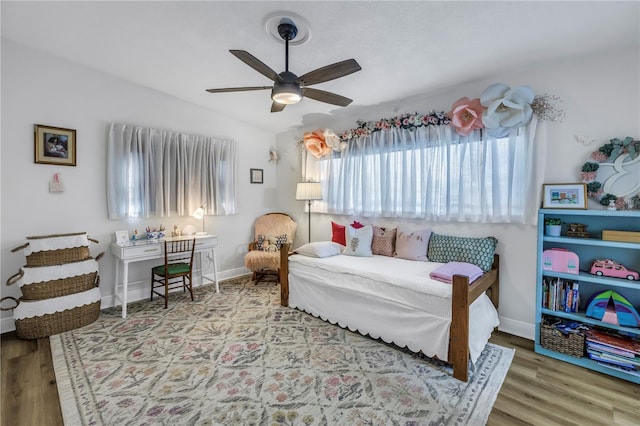 bedroom with a ceiling fan, baseboards, vaulted ceiling, and wood finished floors