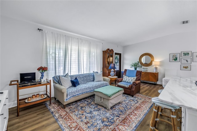 living room featuring baseboards, visible vents, and wood finished floors